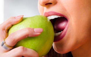 a woman eating green apple