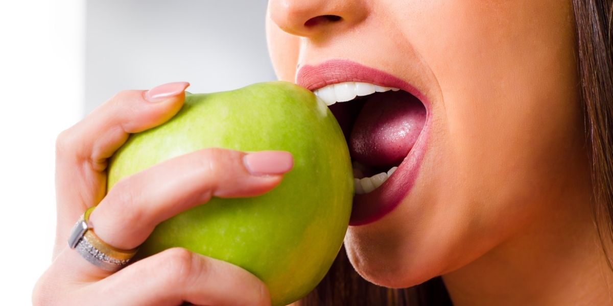 a woman eating green apple